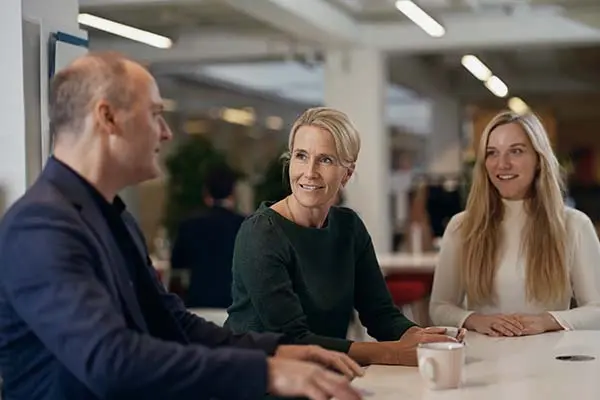 Tre personer, der taler med hinanden